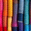 Various spools of colorful yarn representing material sourcing